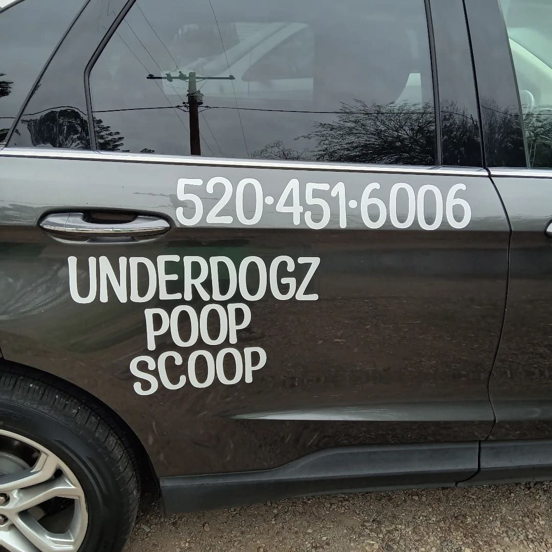 The Underdogz Poop Scoop vehicle with the company name and phone number on the door.